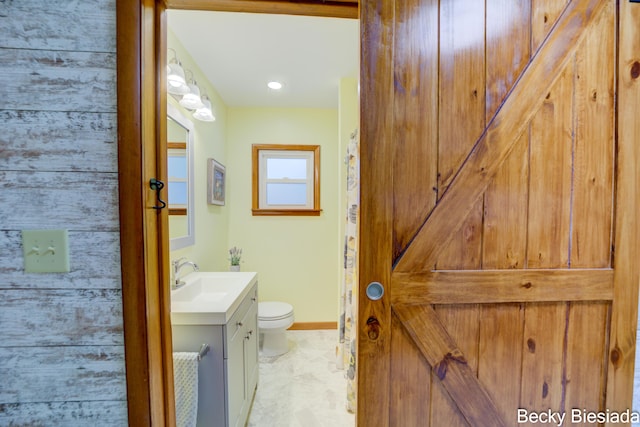 bathroom with vanity, toilet, and baseboards