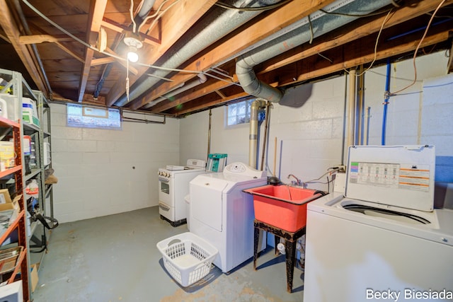 washroom featuring washing machine and dryer, laundry area, and a sink