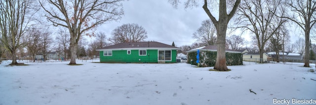 snow covered rear of property with fence