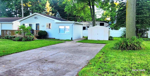 view of front facade with a storage shed, an outbuilding, fence, a deck, and a front lawn