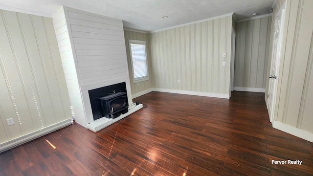 unfurnished living room with ornamental molding, a wood stove, baseboards, and wood finished floors