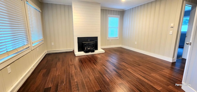 unfurnished living room featuring ornamental molding, a baseboard heating unit, dark wood-type flooring, and baseboards