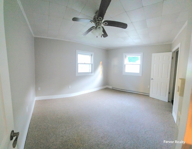 spare room with carpet floors, a healthy amount of sunlight, a baseboard heating unit, and ornamental molding