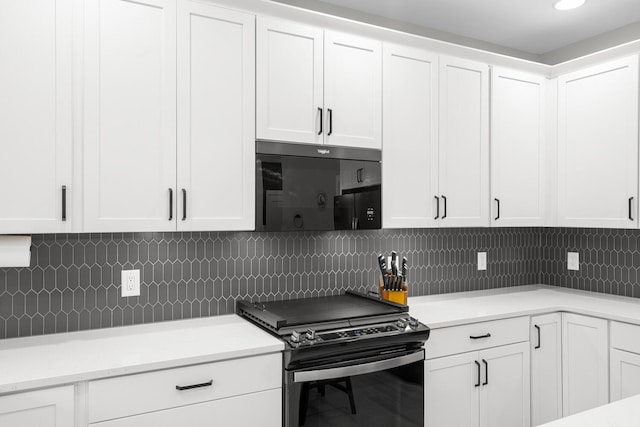 kitchen featuring black appliances, tasteful backsplash, and white cabinetry