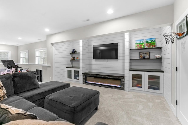 carpeted living room featuring recessed lighting, visible vents, and a glass covered fireplace