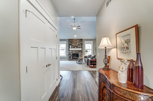 hall featuring lofted ceiling, visible vents, and wood finished floors