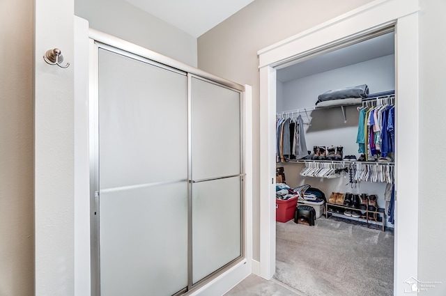 bathroom with a stall shower and a spacious closet