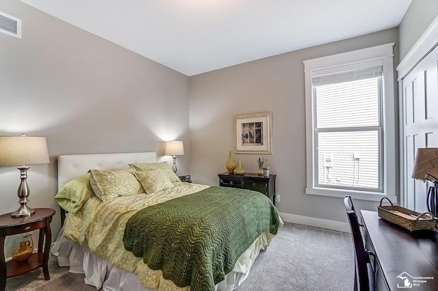 carpeted bedroom featuring visible vents and baseboards