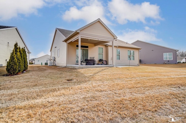 back of house featuring central air condition unit, a lawn, and a patio