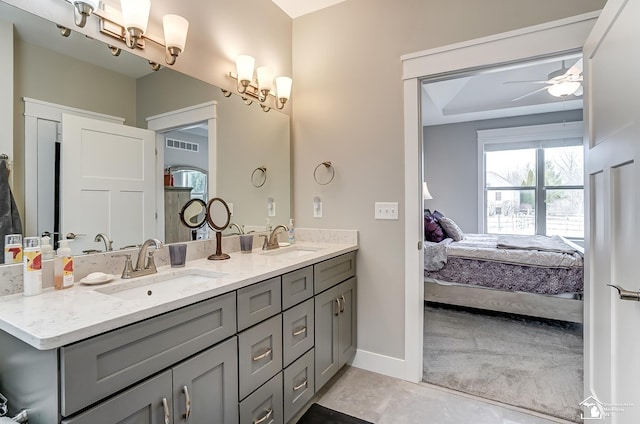 bathroom with ceiling fan, double vanity, a sink, and ensuite bathroom