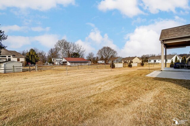 view of yard featuring a residential view, fence, and a patio