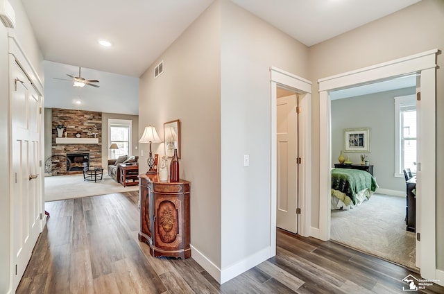 hallway featuring visible vents, baseboards, and wood finished floors