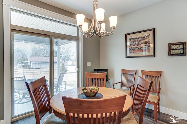 dining room featuring an inviting chandelier, wood finished floors, and baseboards