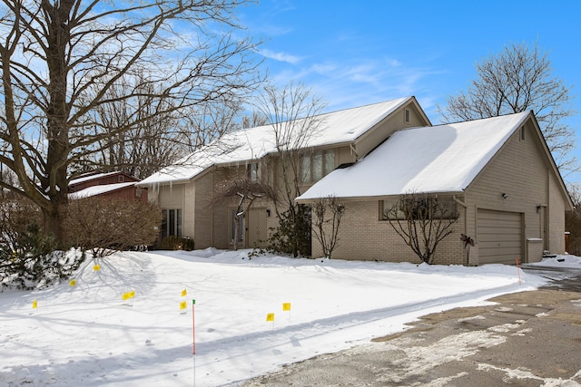 view of front of property featuring brick siding and a detached garage