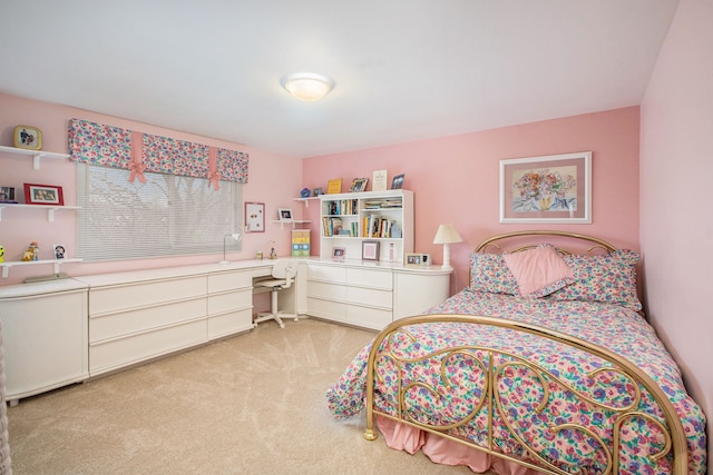 bedroom with built in study area and light carpet