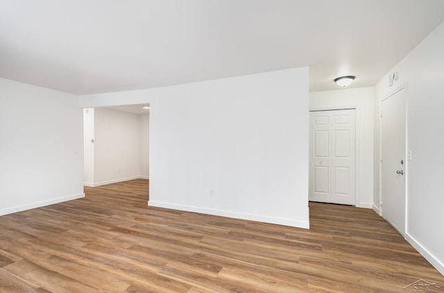 unfurnished room with baseboards and wood finished floors