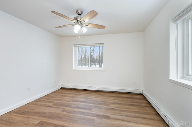 spare room with ceiling fan, a baseboard radiator, wood finished floors, and baseboards