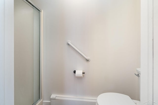 bathroom with a baseboard radiator, a shower with door, and toilet