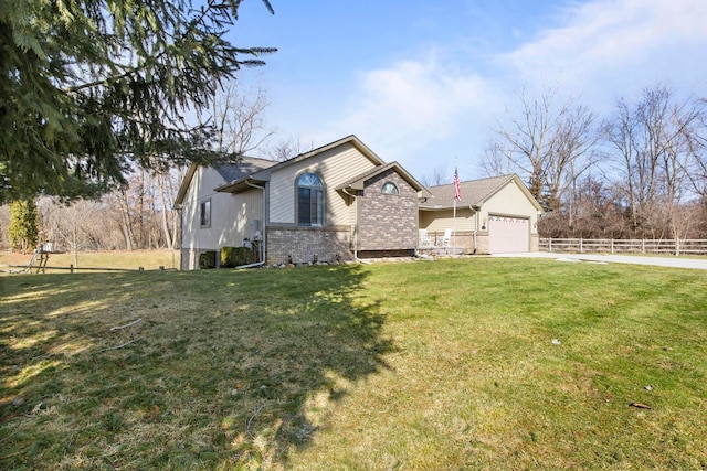 view of front of property with a front lawn, an attached garage, fence, and brick siding