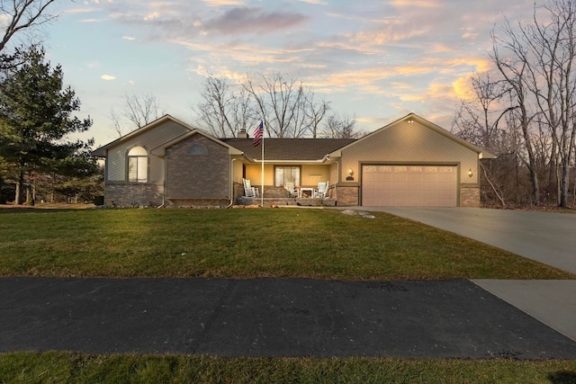 view of front facade featuring brick siding, a lawn, an attached garage, and concrete driveway