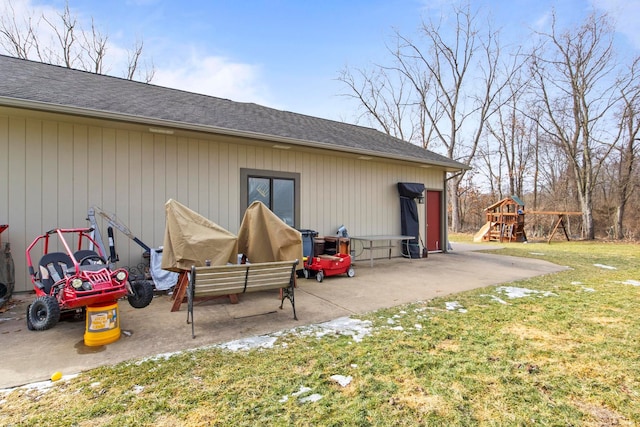 exterior space with a patio, a playground, a yard, and a shingled roof