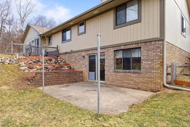 back of property featuring fence, stairs, a lawn, a patio area, and brick siding