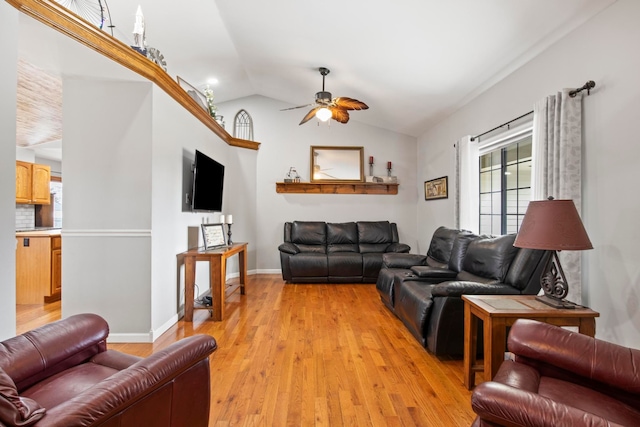 living area with vaulted ceiling, a ceiling fan, light wood-type flooring, and baseboards