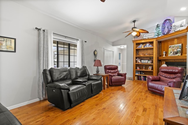 living room featuring lofted ceiling, baseboards, light wood-type flooring, and ceiling fan