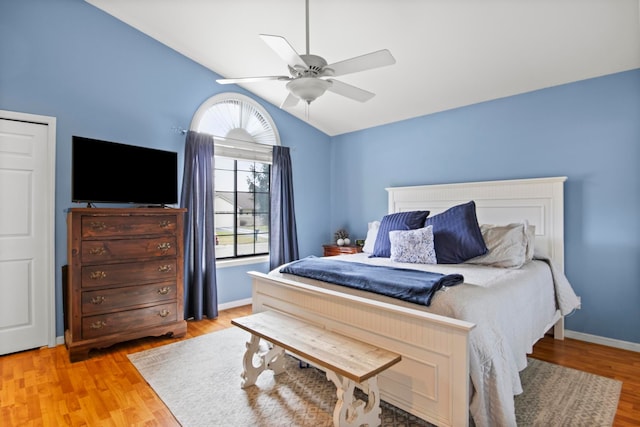 bedroom with lofted ceiling, light wood-style flooring, baseboards, and ceiling fan