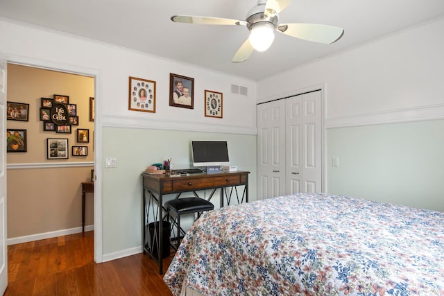 bedroom with baseboards, visible vents, dark wood finished floors, a closet, and crown molding