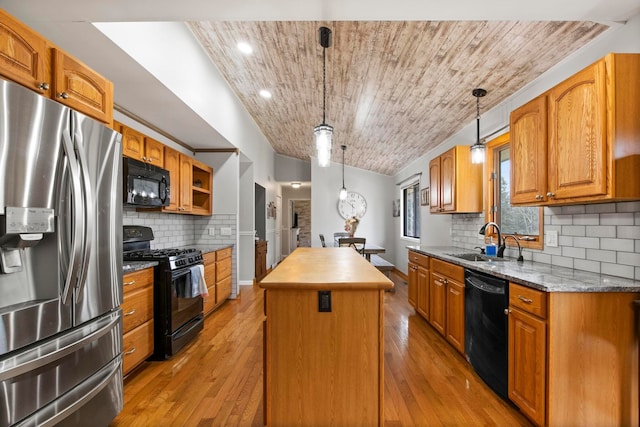 kitchen with a sink, black appliances, a center island, and pendant lighting