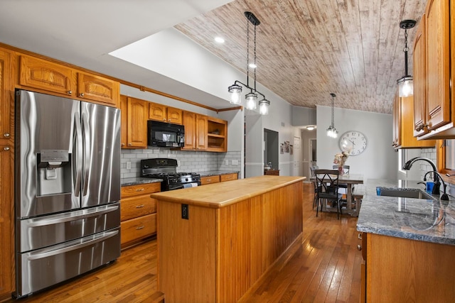 kitchen featuring a kitchen island, lofted ceiling, a sink, black appliances, and tasteful backsplash