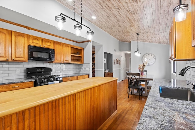 kitchen featuring black appliances, a sink, tasteful backsplash, wooden counters, and vaulted ceiling