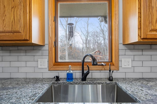 kitchen with a sink, tasteful backsplash, and brown cabinetry