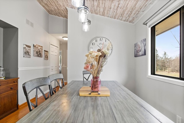 dining space featuring baseboards, visible vents, lofted ceiling, and wood ceiling