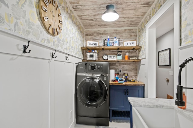 clothes washing area with cabinet space, washer / dryer, wood ceiling, and a sink