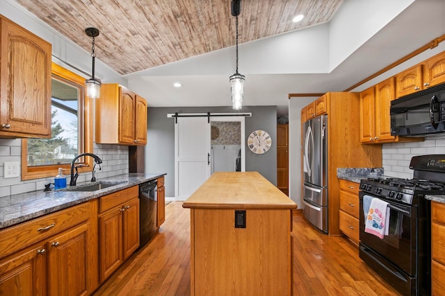 kitchen featuring a kitchen island, wood ceiling, a barn door, vaulted ceiling, and black appliances