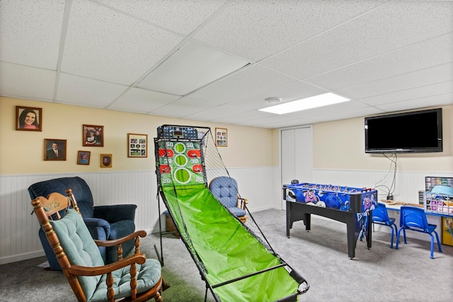 game room featuring a paneled ceiling, carpet, and wainscoting