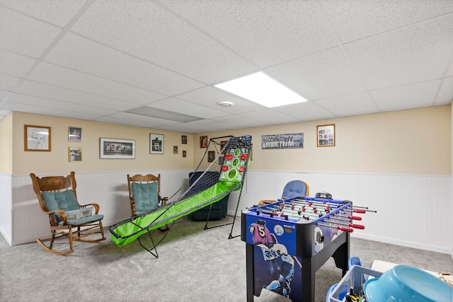 rec room featuring a drop ceiling, carpet flooring, and wainscoting