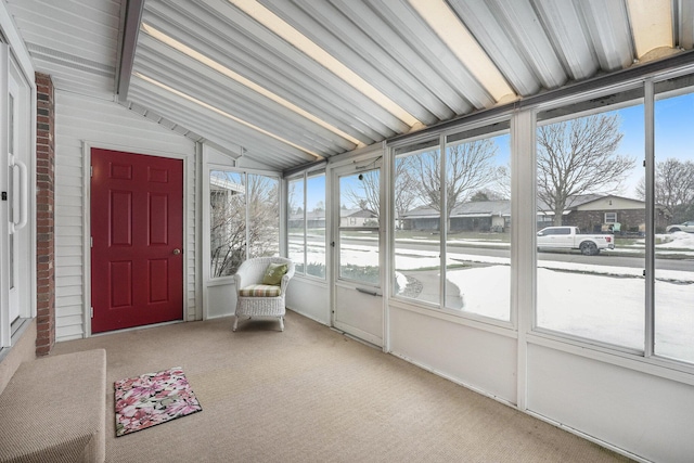 unfurnished sunroom featuring lofted ceiling with beams