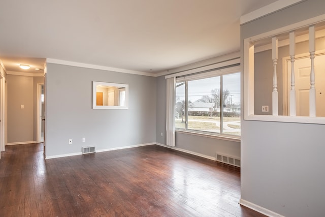 spare room with dark wood-style floors, visible vents, and crown molding