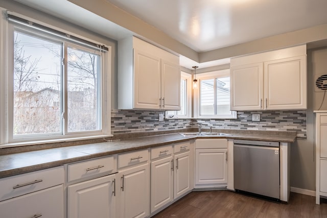 kitchen with stainless steel dishwasher, a sink, and white cabinetry