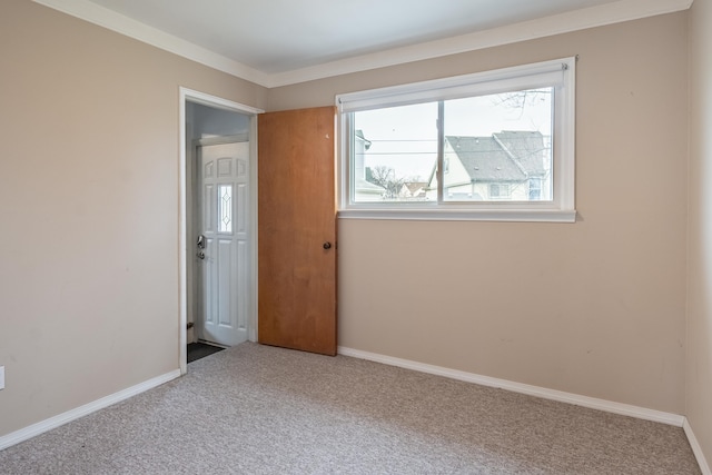 carpeted spare room featuring baseboards