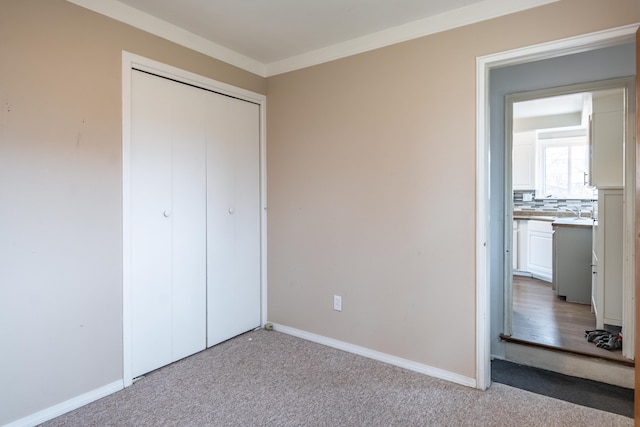 unfurnished bedroom with a closet, carpet flooring, and baseboards