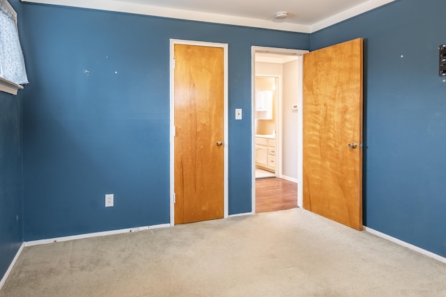 unfurnished bedroom featuring carpet and baseboards