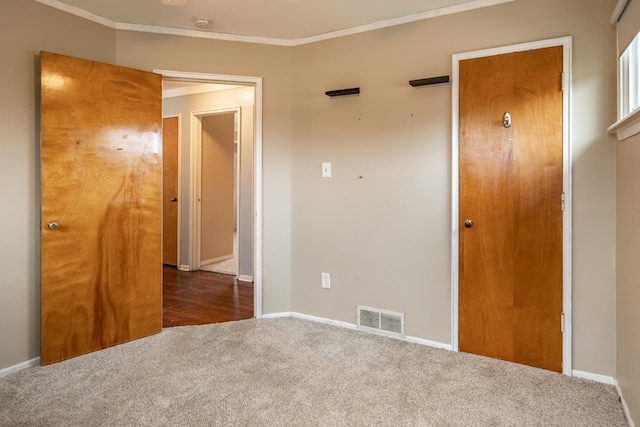 interior space featuring carpet, visible vents, baseboards, and ornamental molding