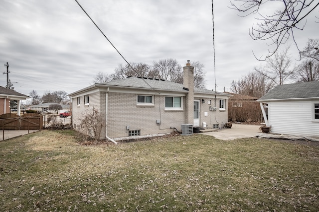 rear view of house with a lawn, a chimney, fence, a patio area, and brick siding