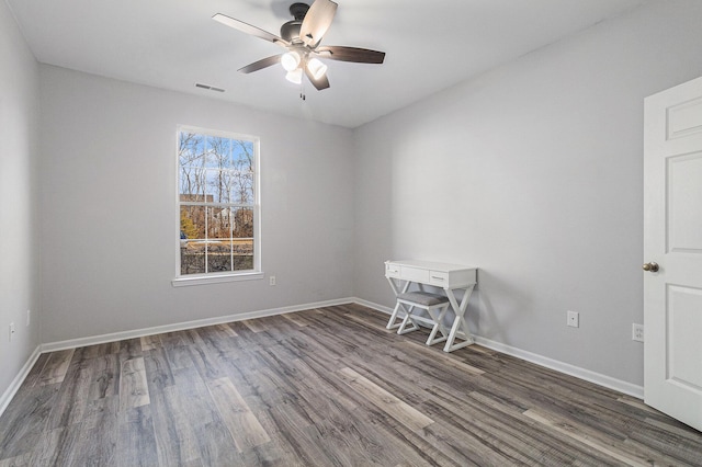 spare room with visible vents, baseboards, and wood finished floors