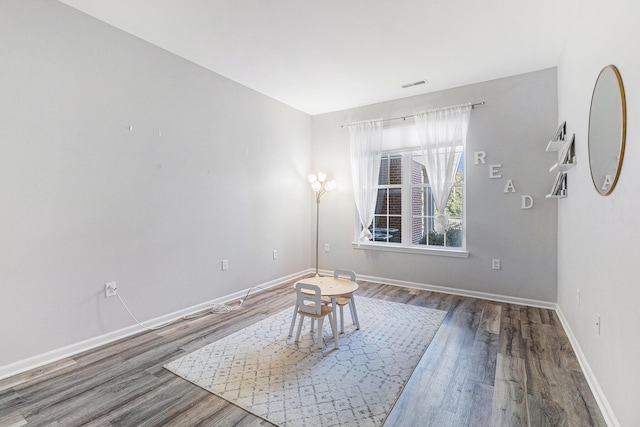 unfurnished room with visible vents, baseboards, and wood finished floors