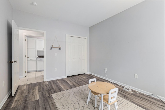 unfurnished bedroom featuring a closet, baseboards, and wood finished floors